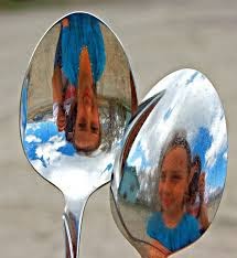 A silvered or shinny spoon can act as  spherical mirror where one side is convex and other side is concave mirror.